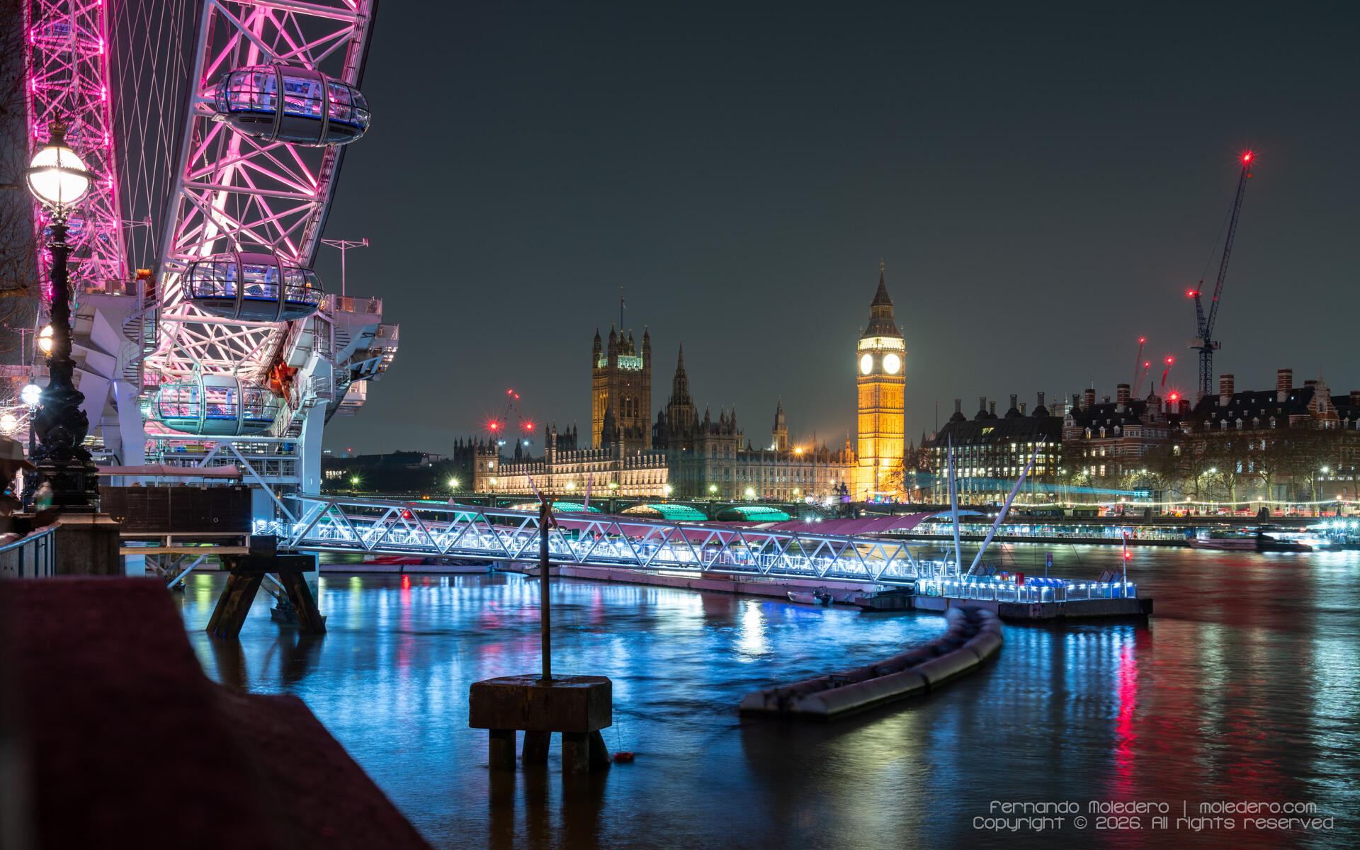 Night view of the London Eye beside the River Thames, with the illuminated Palace of Westminster and Big Ben in the background