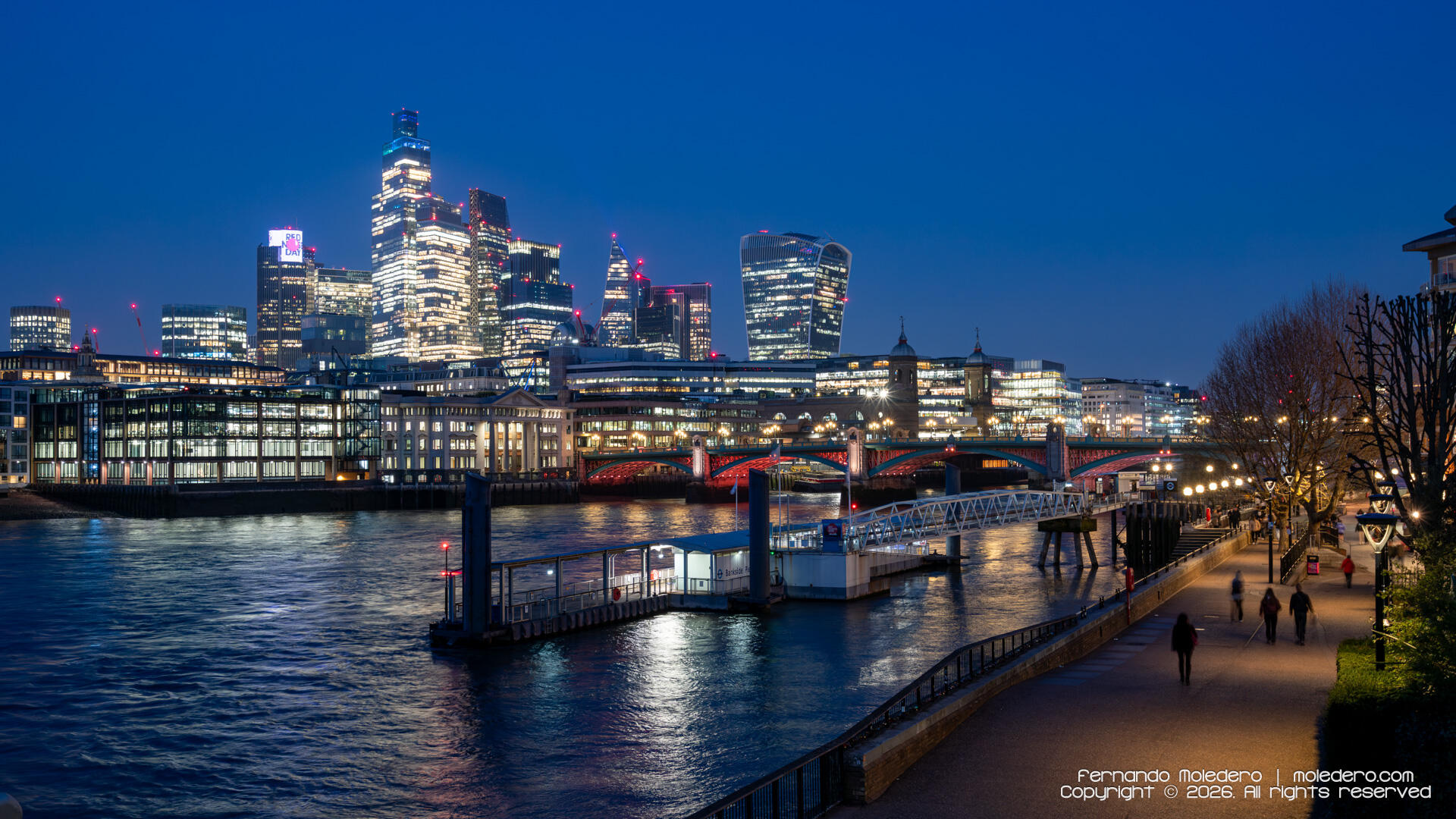Evening view of Blackfriars Bridge over the River Thames with illuminated skyscrapers of the City of London skyline in the background