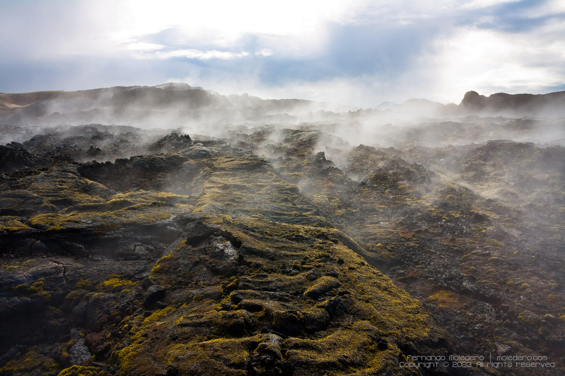 Steam rising from moss-covered lava fields at Krafla volcano in Iceland, highlighting the geothermal activity and rugged volcanic terrain